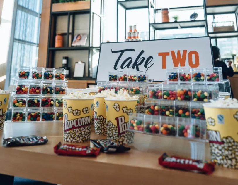 A table full of colourful sweets and popcorn.